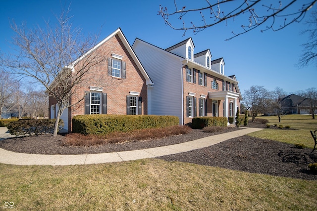 view of side of home featuring a yard and brick siding