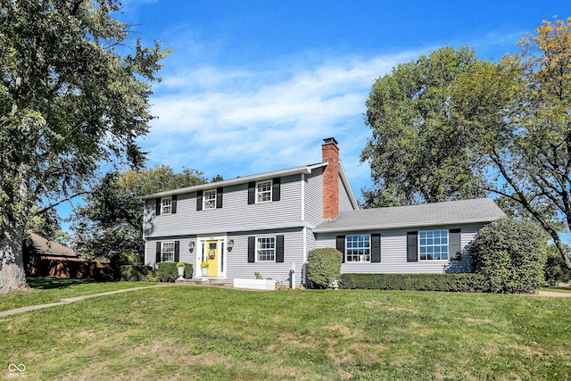 colonial house with a chimney and a front yard