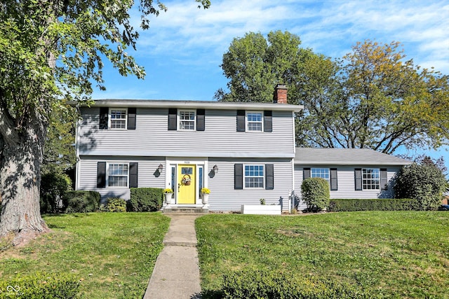 colonial home with a front lawn and a chimney