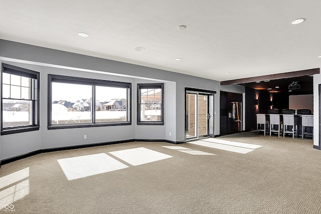 unfurnished living room featuring a textured ceiling and light carpet