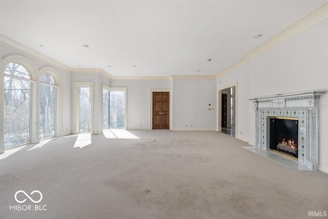 unfurnished living room featuring ornamental molding, light colored carpet, and a premium fireplace