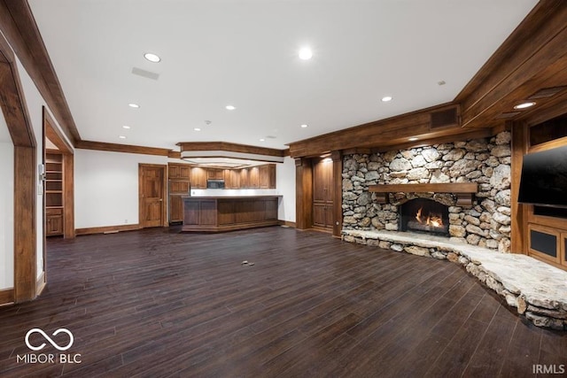 unfurnished living room featuring crown molding, dark wood-type flooring, and a fireplace