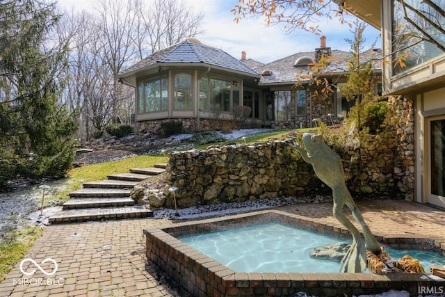 view of pool featuring a sunroom and an outdoor hot tub