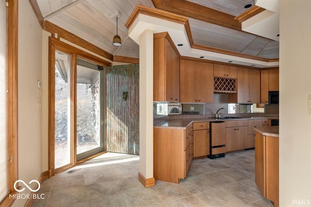 kitchen with paneled dishwasher, sink, backsplash, a raised ceiling, and crown molding