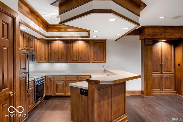 kitchen with stainless steel electric range oven, a breakfast bar, dark hardwood / wood-style flooring, a kitchen island, and sink