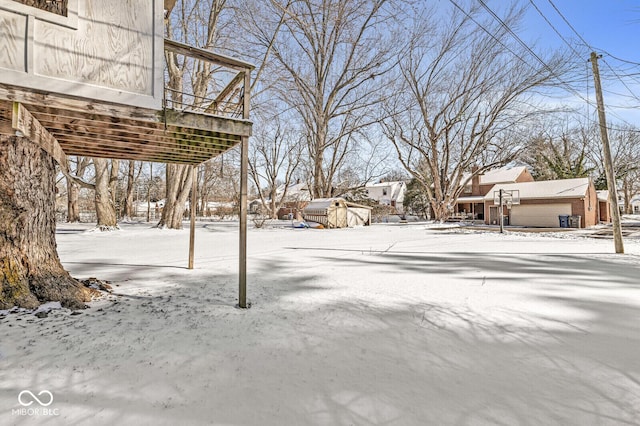 yard covered in snow featuring a storage shed