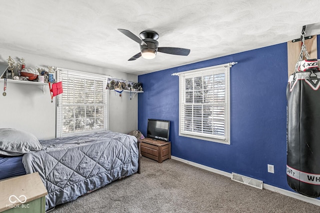 bedroom featuring ceiling fan, carpet floors, and a textured ceiling