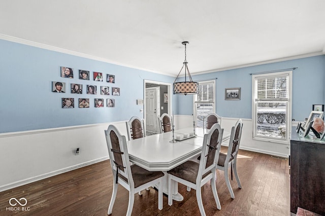 dining area with dark hardwood / wood-style flooring and crown molding