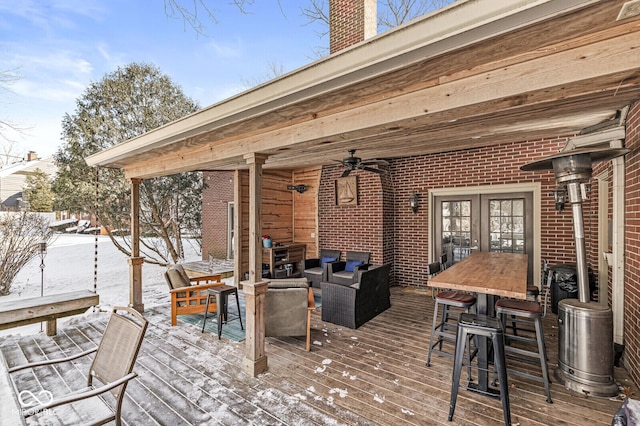 snow covered deck featuring french doors, an outdoor hangout area, and ceiling fan