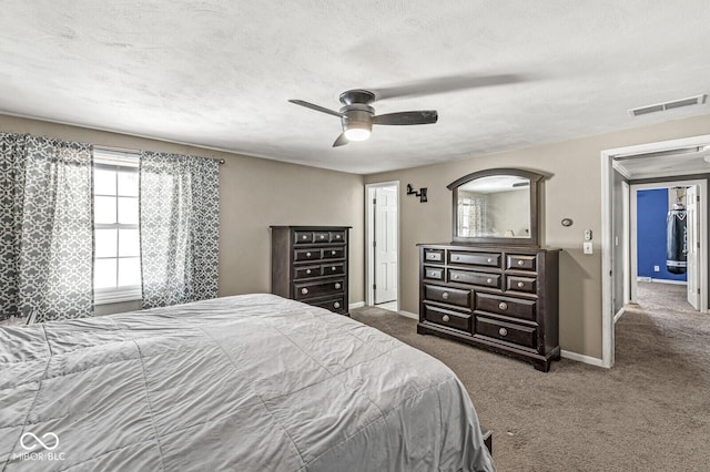 carpeted bedroom with ceiling fan and a textured ceiling