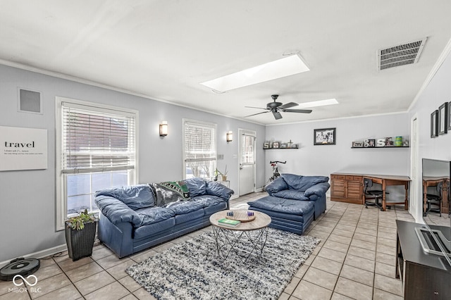 tiled living room featuring ceiling fan, ornamental molding, and a skylight