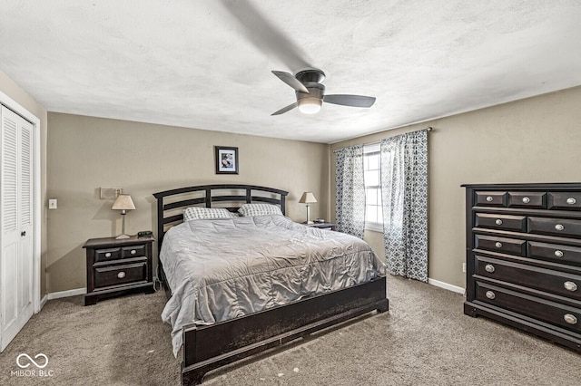 bedroom featuring a closet, ceiling fan, dark colored carpet, and a textured ceiling