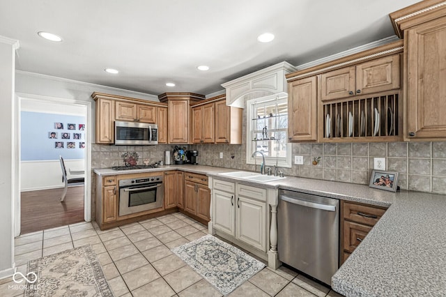 kitchen with appliances with stainless steel finishes, light tile patterned floors, sink, and ornamental molding