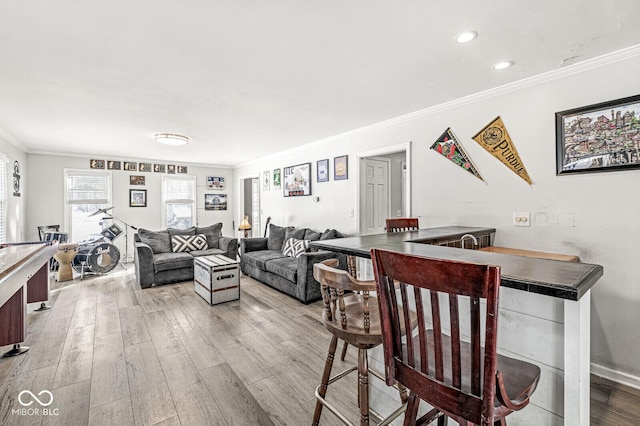 living room with light wood-type flooring and crown molding