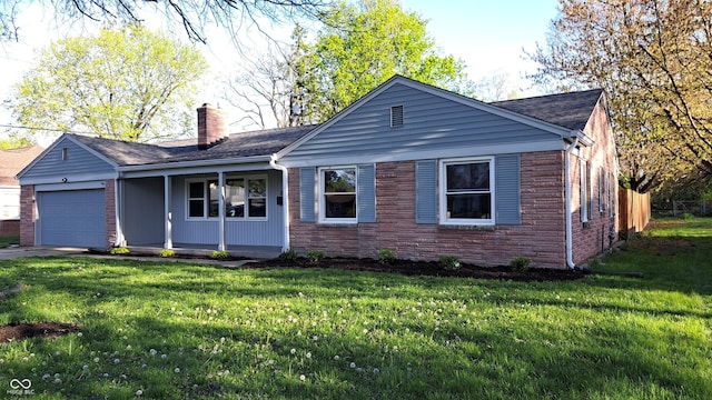 3121 W 13th St, Anderson, IN 46011 - single story home with covered porch, a chimney, a front yard, and a garage