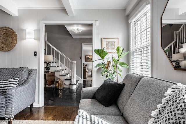 living area featuring stairway, beamed ceiling, wood finished floors, and crown molding