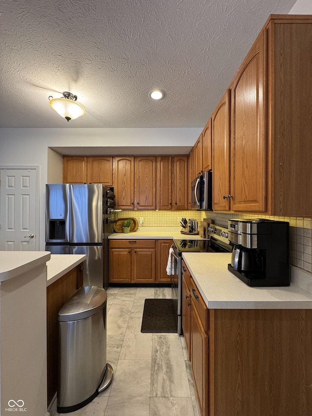 kitchen featuring stainless steel appliances, a textured ceiling, and tasteful backsplash