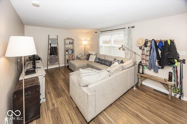 living area with visible vents, baseboards, and wood finished floors