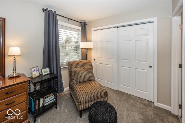 sitting room featuring baseboards and dark colored carpet