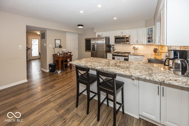 kitchen featuring visible vents, dark wood finished floors, white cabinetry, appliances with stainless steel finishes, and a peninsula