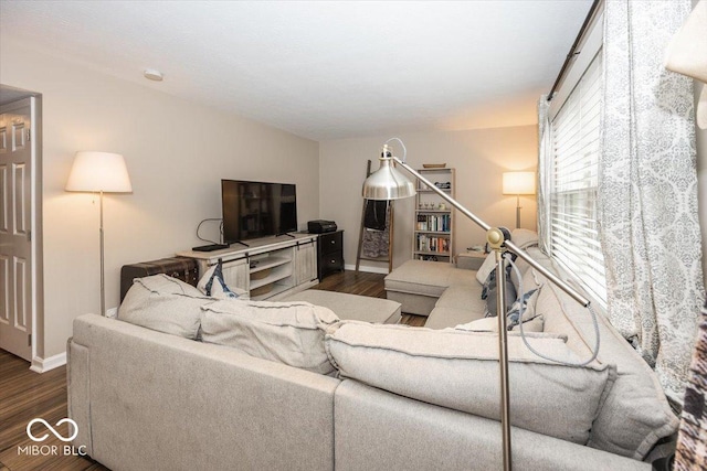 living area with dark wood-type flooring and baseboards