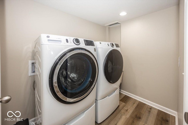 washroom featuring wood finished floors, baseboards, laundry area, recessed lighting, and washer and clothes dryer