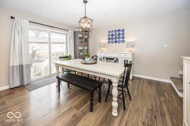 dining area featuring a notable chandelier, dark wood-type flooring, and baseboards