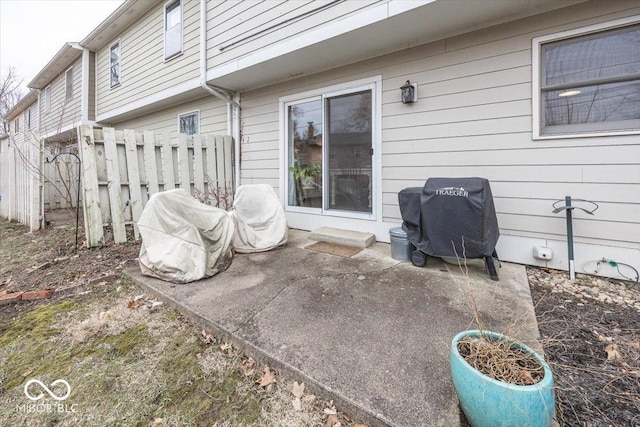 view of patio featuring a grill and fence