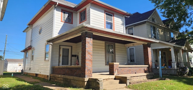 view of front of home with covered porch and a front yard