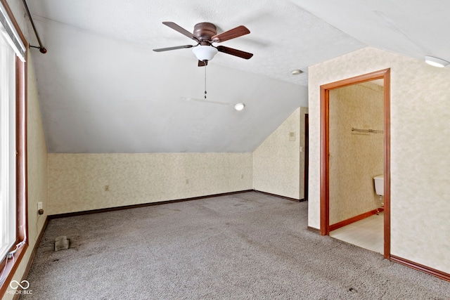 additional living space featuring lofted ceiling, ceiling fan, carpet floors, and a textured ceiling