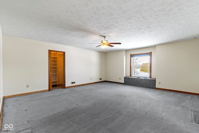 carpeted empty room featuring a textured ceiling and ceiling fan