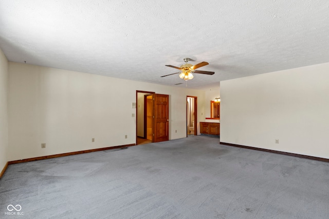 unfurnished room with light carpet, ceiling fan, and a textured ceiling