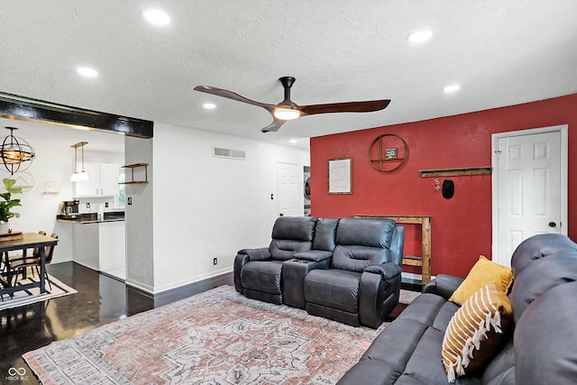 living room with wood-type flooring, ceiling fan, and a textured ceiling