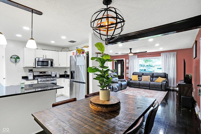 dining space with ceiling fan with notable chandelier, wood-type flooring, and a textured ceiling