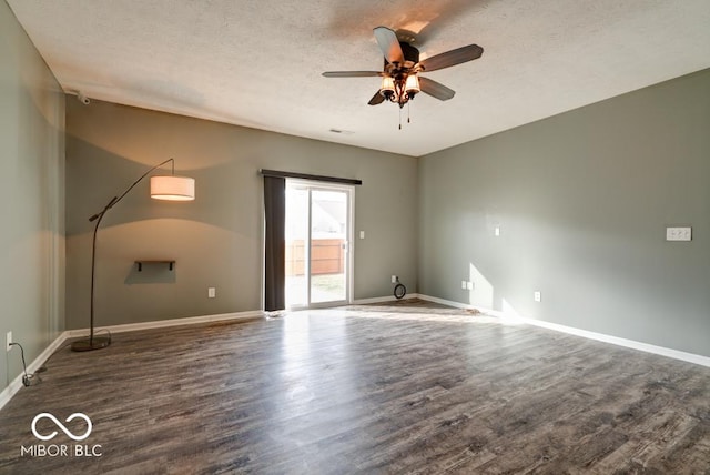 empty room featuring dark wood-style floors, ceiling fan, a textured ceiling, and baseboards