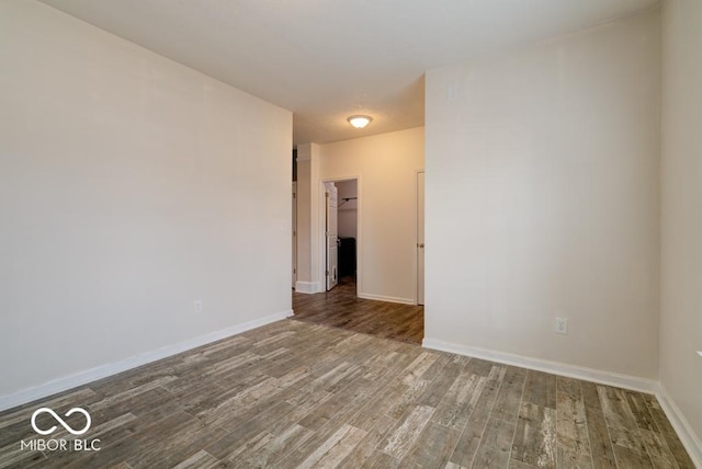 empty room with baseboards and wood finished floors