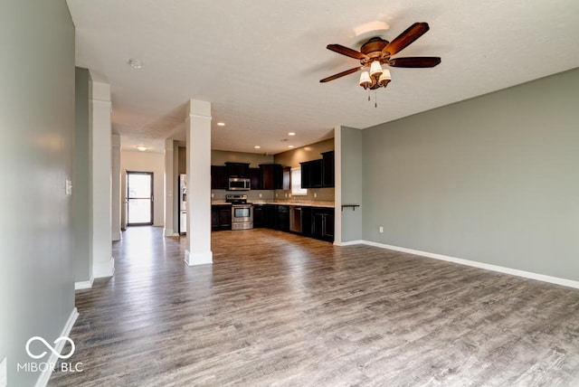 unfurnished living room with ceiling fan, recessed lighting, wood finished floors, and baseboards