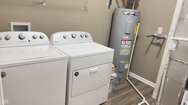 laundry area with laundry area, baseboards, dark wood-type flooring, independent washer and dryer, and water heater