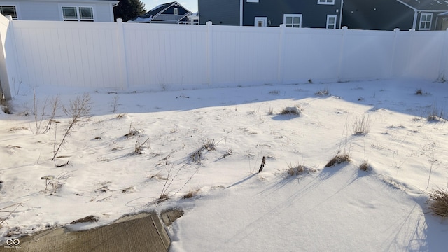 yard layered in snow featuring fence