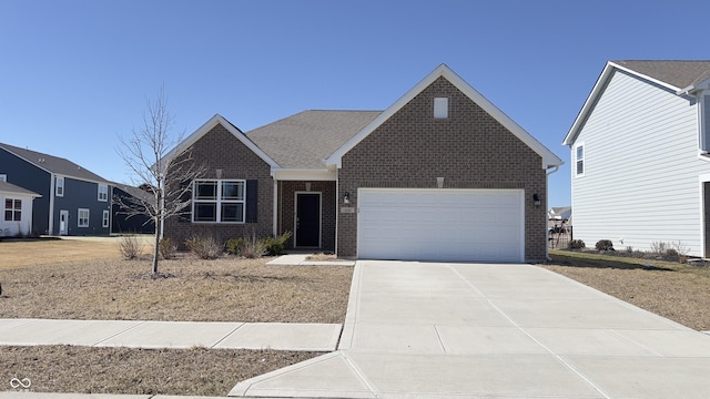 view of front facade with a shingled roof, concrete driveway, brick siding, and an attached garage