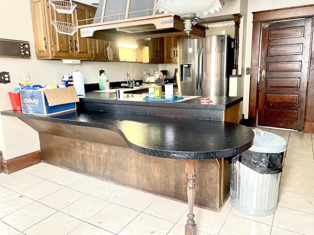 600 N Meridian St, Brazil, IN 47834 - kitchen featuring stainless steel refrigerator with ice dispenser, a peninsula, dark countertops, baseboards, and light tile patterned flooring