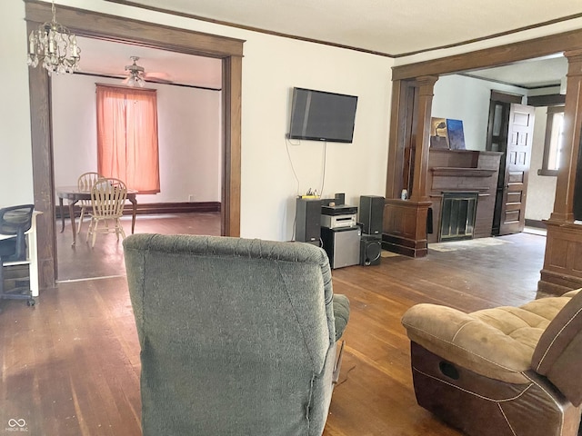 600 N Meridian St, Brazil, IN 47834 - living area with decorative columns, wood finished floors, crown molding, a fireplace, and a ceiling fan