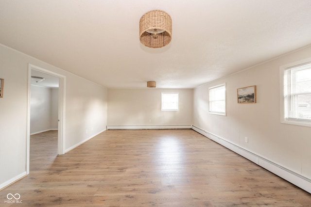 unfurnished room featuring light wood finished floors, baseboard heating, and baseboards