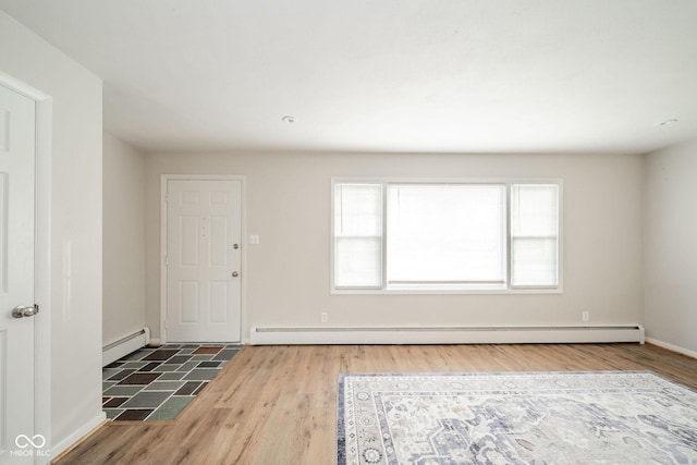 entrance foyer featuring a baseboard radiator, baseboards, and wood finished floors