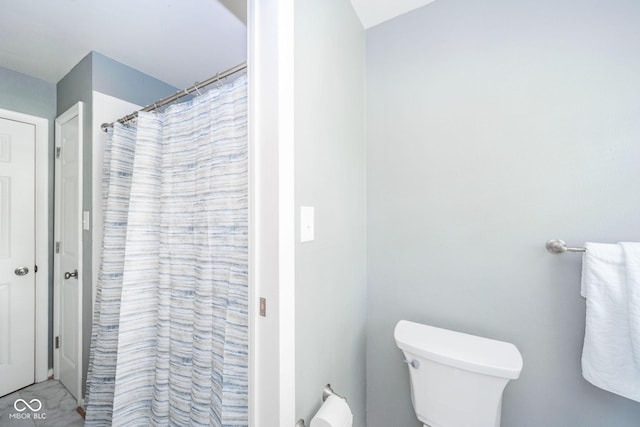 bathroom featuring a shower with shower curtain and toilet