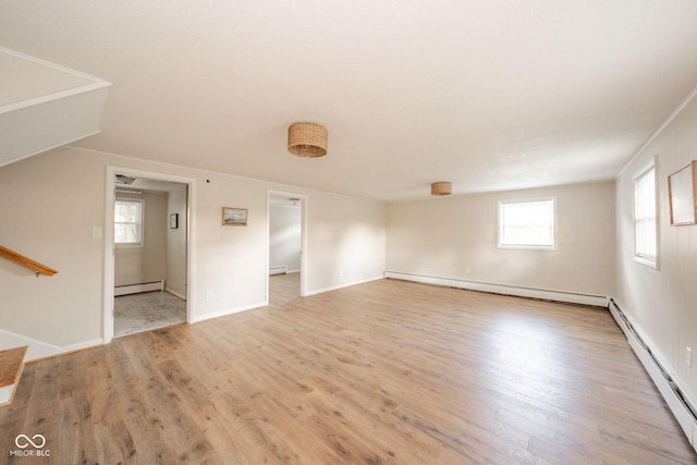 spare room with a baseboard heating unit, light wood finished floors, and baseboard heating