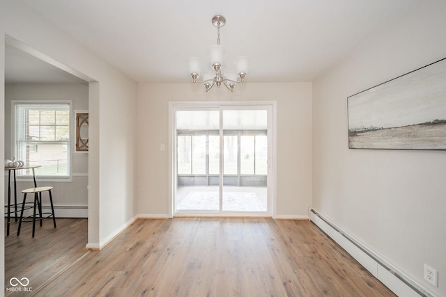 dining area with a chandelier, a baseboard radiator, and light wood-style floors