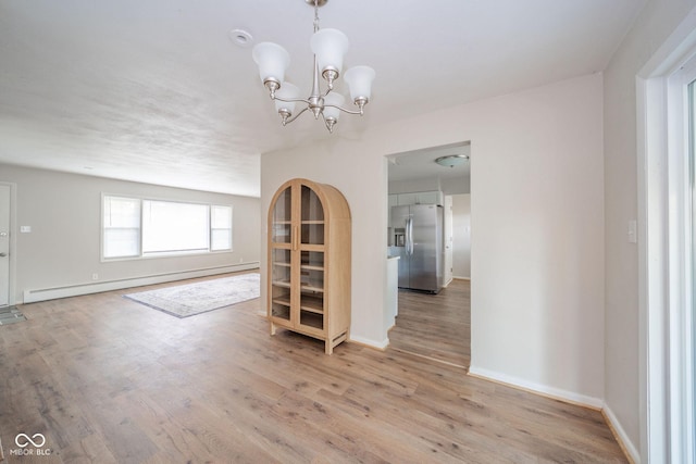 unfurnished dining area with baseboards, baseboard heating, and light wood-style floors