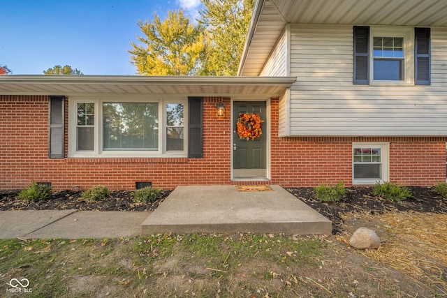 property entrance featuring crawl space and brick siding