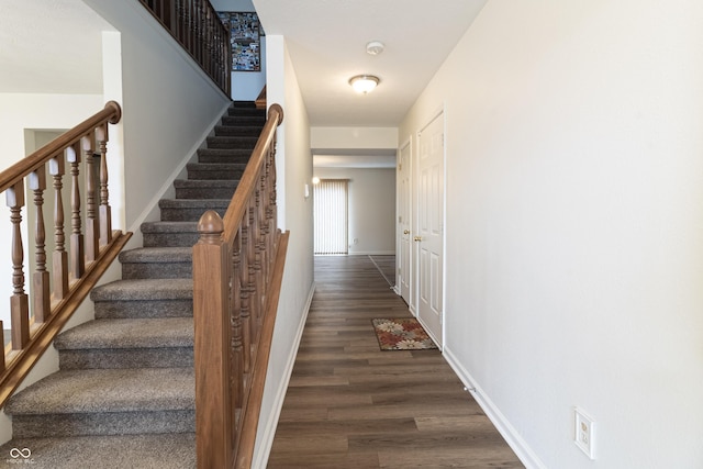 staircase with wood finished floors and baseboards